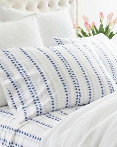 Close up of white bedding with a blue and gray design